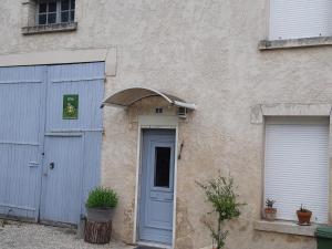 un edificio con una puerta azul y dos garajes en Slow Life House, en Saint-Maurice-sous-les-Côtes