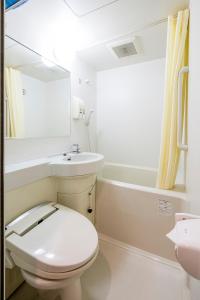 a white bathroom with a toilet and a sink at Sejour Inn Nagarekawa in Hiroshima