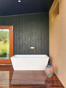 a white bath tub in a room with a vase at Studio 40 in Coromandel Town