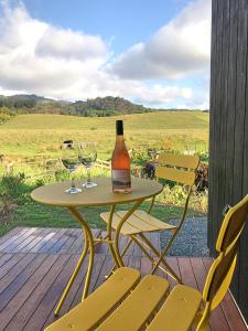 a table with two glasses and a bottle of wine at Studio 40 in Coromandel Town