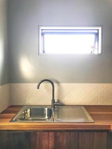 a sink in a kitchen with a window at Studio 40 in Coromandel Town