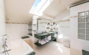 a bathroom with a tub and a sink and a bath tub at Romantik Hotel & Restaurant Stafler in Vipiteno