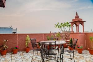 a table and chairs on a patio with potted plants at Marigold Inn- Homestay in Jaipur