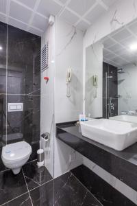 y baño con lavabo, bañera y aseo. en Ankara Vilayetler Evi, en Golbası