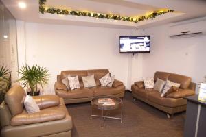 a living room with couches and a flat screen tv at City Hotel Colombo 02 in Colombo