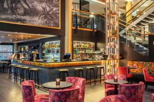 a bar with red chairs and tables in a restaurant at Thon Hotel Opera in Oslo