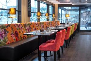 a row of tables with red chairs in a restaurant at Thon Hotel Opera in Oslo