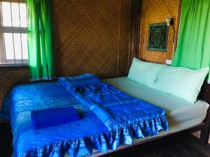 a bed in a room with green curtains at Golden Hut -Chill Bungalows in town黄金泰式传统独栋小屋 in Pai