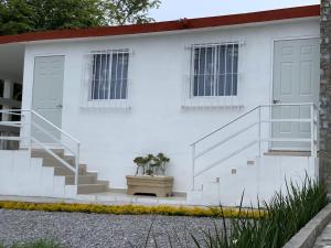 a white house with stairs and two windows at Lofts Zaragoza in Valles