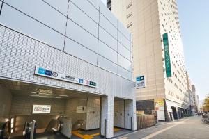 a building with a sign on the side of it at Sotetsu Fresa Inn Higashi Shinjuku in Tokyo