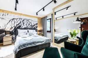 - une chambre avec un lit king-size et une chaise dans l'établissement Apartament SKI, à Zakopane