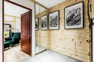 a hallway with a wooden wall with framed pictures at Apartament SKI in Zakopane