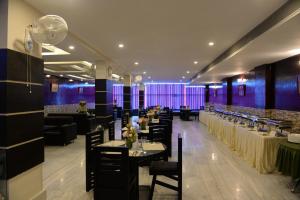 a restaurant with tables and chairs and purple walls at Hotel Lake Shilloi in Dimāpur