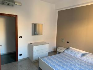 1 dormitorio con 1 cama y vestidor en la casa blu, en Roccella Ionica