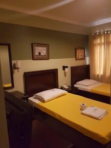 een hotelkamer met 2 bedden en een spiegel bij ROLET HOTEL in Catbalogan