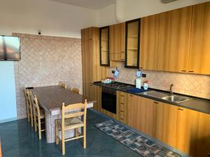 a kitchen with wooden cabinets and a table with chairs at la casa blu in Roccella Ionica