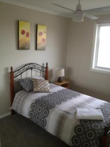 
a bedroom with a bed, a lamp, and a window at Denman Serviced Apartments in Denman
