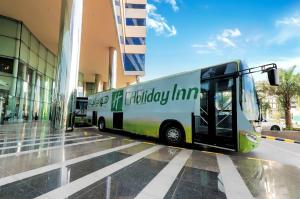 a bus parked in front of a building at Holiday Suites Al Azizia in Makkah