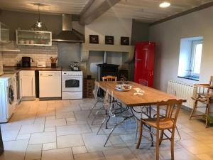 a kitchen with a wooden table and a red refrigerator at Les Marguerites in Palinges