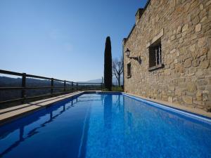 a large swimming pool next to a stone building at Casa del Moliner in Boada
