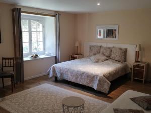 una camera con un grande letto e una finestra di Le Domaine Des Platanes a Bourg-Charente