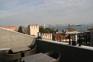 balkon ze stołem i krzesłami oraz widokiem na wodę w obiekcie Ligos w Stambule