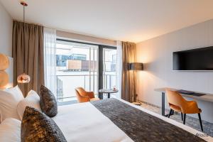 Rúm í herbergi á Hotel Restaurant Van Der Valk Nivelles-Sud