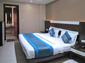 una camera da letto con un grande letto con cuscini blu di Raj Mahal Inn a Nuova Delhi