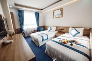 Giường trong phòng chung tại Rum Vang Hotel Da Lat