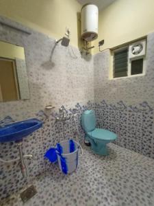 een badkamer met een blauw toilet en een wastafel bij Le CharMin in Kodaikānāl