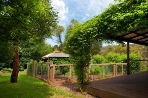 a wooden boardwalk with a gazebo in a garden at Kookaburra Ridge in Hepburn