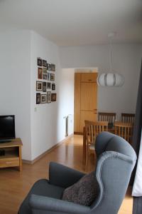 uma sala de estar com um sofá, uma cadeira e uma mesa em Ferienresidenz Wurmbergblick em Braunlage