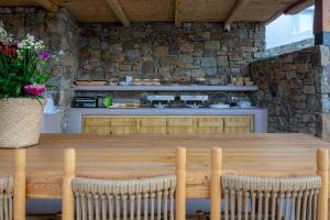 a kitchen with a wooden table and a counter at Aelia Mykonos in Ornos