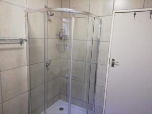 a shower with a glass door in a bathroom at Home @ Harry's in Pretoria