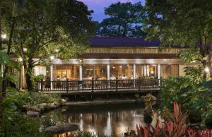 a restaurant with a pond in front of a building at Dusit Thani Manila in Manila