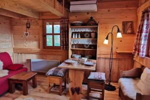 una sala de estar con una mesa en una cabaña de madera en Au petit chalet avec son SPA - Escapade en amoureux ! en Cruet