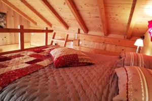a bedroom with a bed in a wooden cabin at Au petit chalet avec son SPA - Escapade en amoureux ! in Cruet