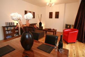 a living room with a vase with flowers on a table at Chaucer Apartment in Keswick