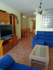 a living room with a blue couch and a tv at Apartamento Maravillas in Caravaca de la Cruz