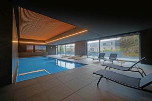 a house with a swimming pool with chairs and a couch at MY HOTEL MALMEDY in Malmedy