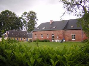 a large brick building with tables and chairs in front of it at La Ferme Pillet in Berville