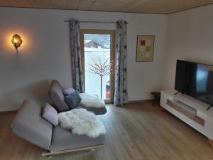 a living room with a couch and a television at Chalet Vacanza in Brand