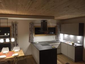 a kitchen with a sink and a table with chairs at Chalet Vacanza in Brand