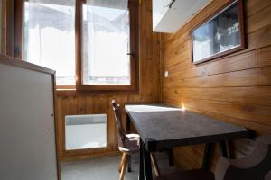 エクスレバンにあるT1 situé à 100 m des thermesのテーブルと窓が備わる小さな客室です。