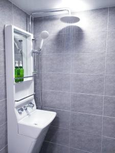 uma casa de banho com um lavatório branco e um chuveiro em Hangeul Guesthouse em Seul