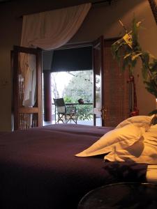 a bedroom with a bed with a view of a patio at Tingala Lodge - Bed in the Bush in Phalaborwa