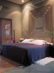 a bedroom with a large bed with a stone wall at Tingala Lodge - Bed in the Bush in Phalaborwa