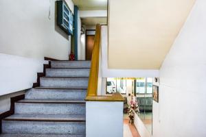 a staircase in a house with blue stairs and a yellow railing at Gedkanok Apartment in Bangkok