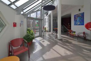 un couloir avec des chaises et des tables dans un bâtiment dans l'établissement Hotel CIS Paris Kellermann, à Paris