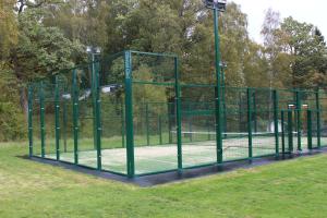 einen Tennisplatz in einem Park mit einem grünen Zaun in der Unterkunft Ollestad gård in Ljung